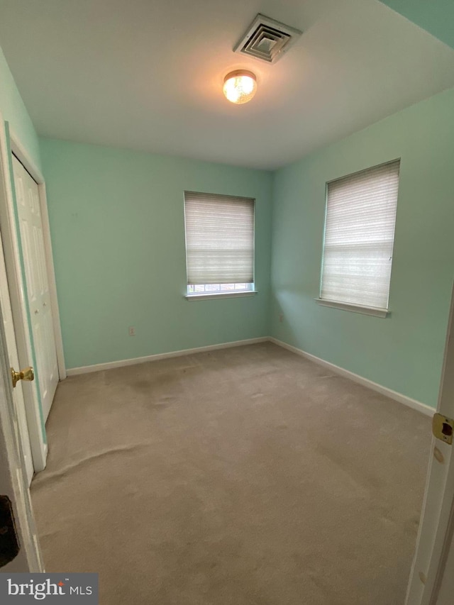 spare room featuring light carpet