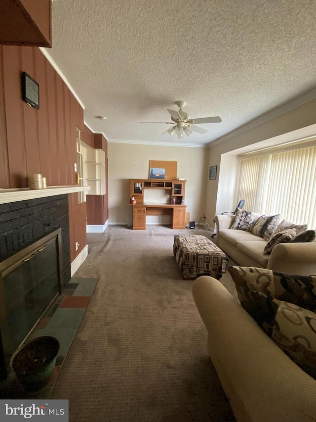 carpeted living room with ceiling fan, a textured ceiling, a brick fireplace, and ornamental molding