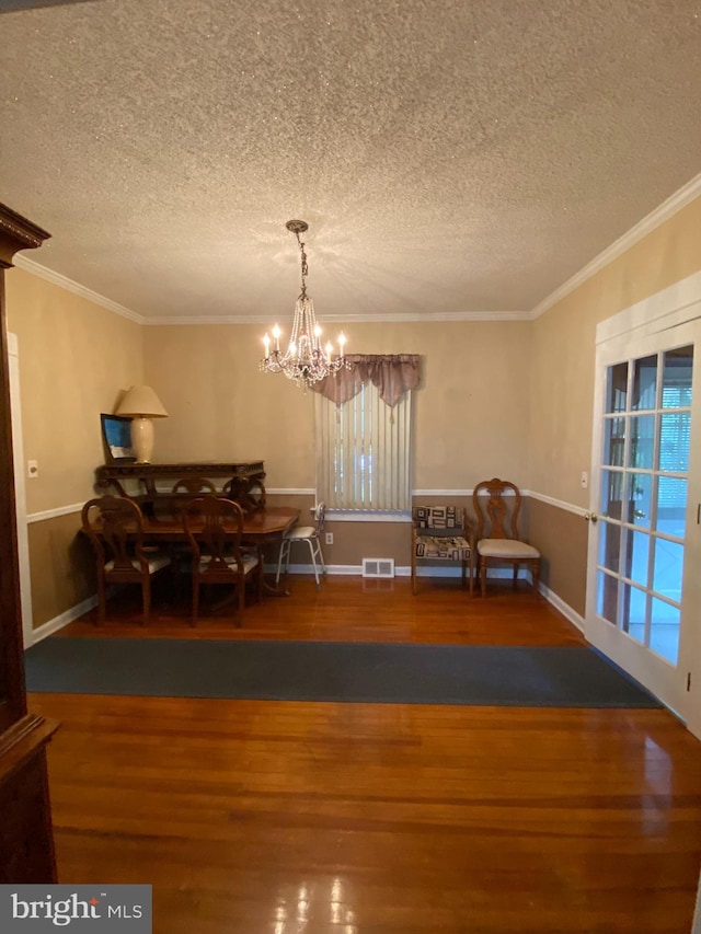 dining room featuring a textured ceiling, dark hardwood / wood-style floors, and a notable chandelier