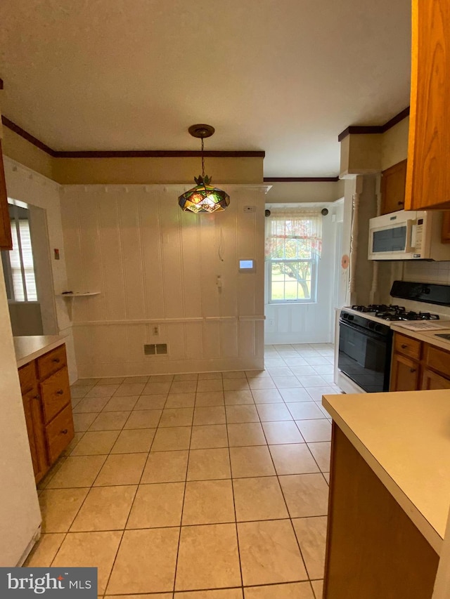 kitchen featuring hanging light fixtures, white appliances, crown molding, and light tile patterned floors