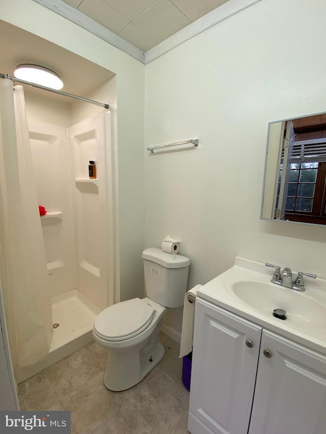 bathroom featuring tile patterned flooring, walk in shower, vanity, and toilet