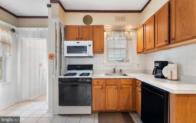 kitchen featuring white appliances, crown molding, light tile patterned flooring, and sink