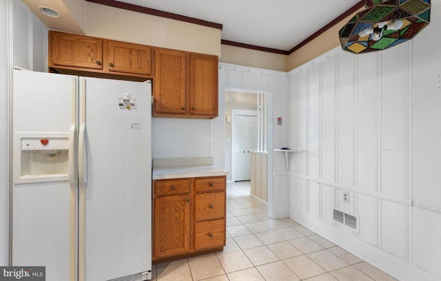 kitchen featuring white refrigerator with ice dispenser, crown molding, and light tile patterned floors