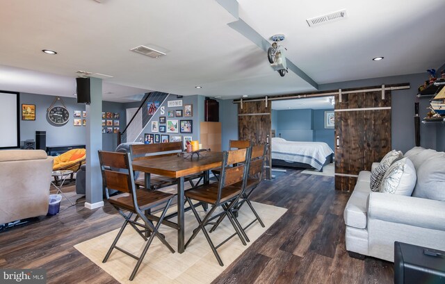 dining space featuring dark wood-type flooring and a barn door