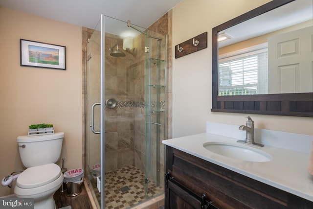 bathroom with vanity, hardwood / wood-style floors, toilet, and a shower with door