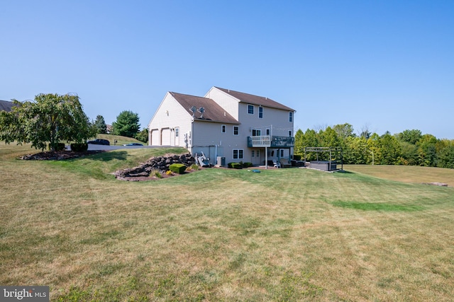 back of property with a garage and a lawn