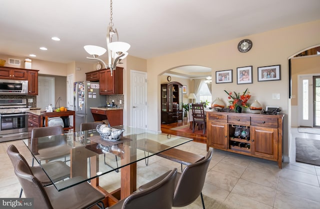 tiled dining space with a chandelier