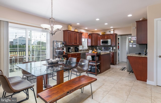 kitchen with appliances with stainless steel finishes, a kitchen island, pendant lighting, and tasteful backsplash