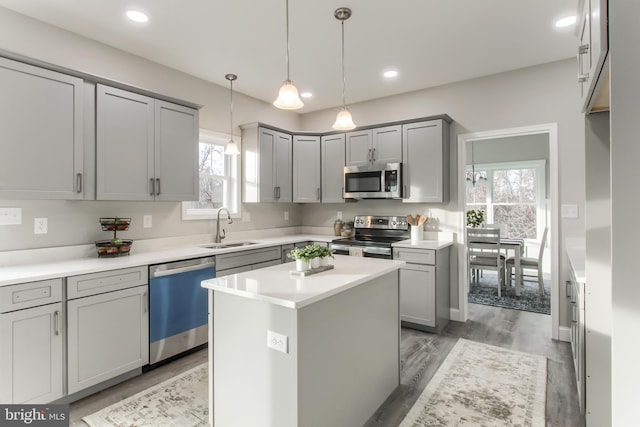 kitchen featuring appliances with stainless steel finishes, a kitchen island, sink, and gray cabinets