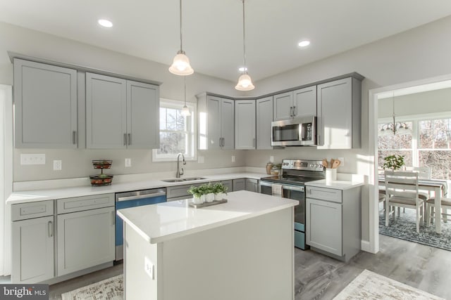 kitchen featuring stainless steel appliances, a center island, plenty of natural light, and sink