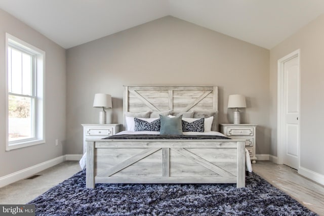 bedroom featuring carpet, vaulted ceiling, and multiple windows