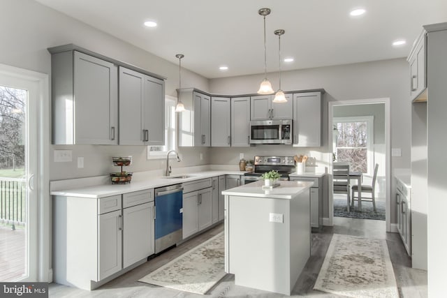 kitchen with stainless steel appliances, plenty of natural light, sink, and a center island