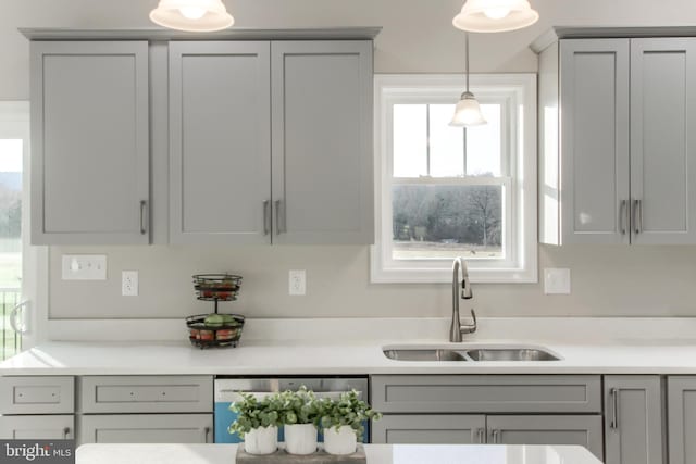 kitchen featuring gray cabinets, dishwasher, decorative light fixtures, and sink