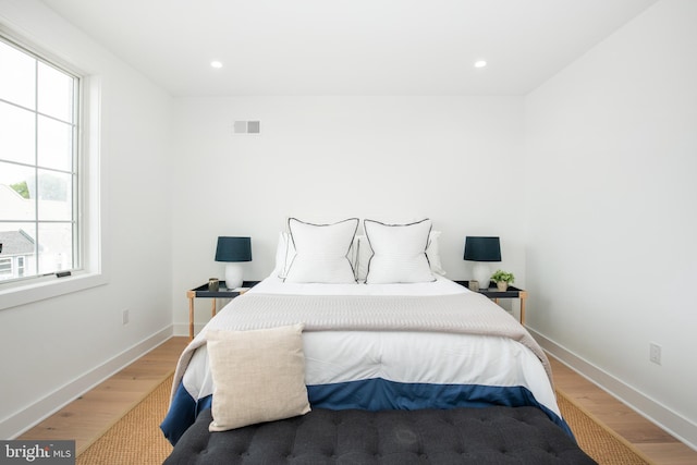 bedroom featuring multiple windows and wood-type flooring