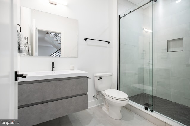 bathroom featuring a shower with shower door, vanity, and toilet