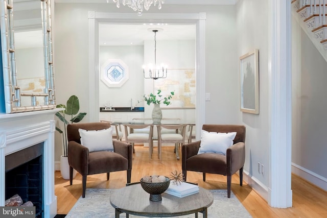 living area featuring a notable chandelier and light wood-type flooring