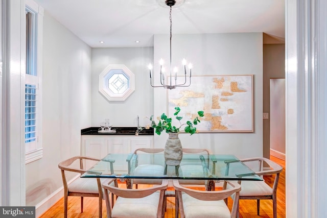 dining room with bar area, an inviting chandelier, light hardwood / wood-style flooring, and plenty of natural light