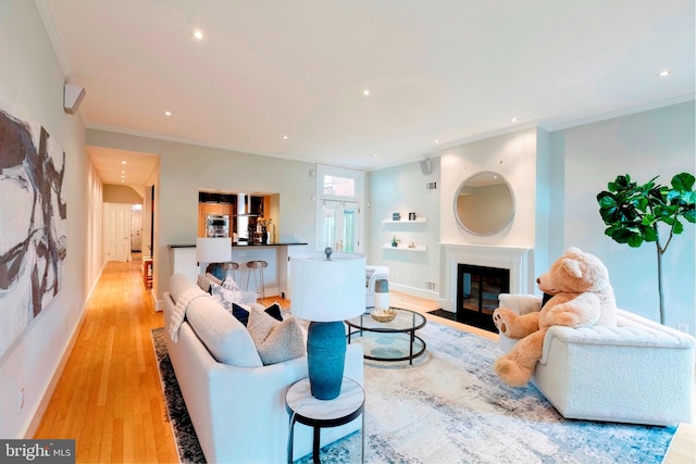 living room featuring crown molding and light hardwood / wood-style floors