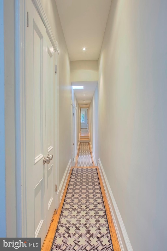 hallway with light hardwood / wood-style floors