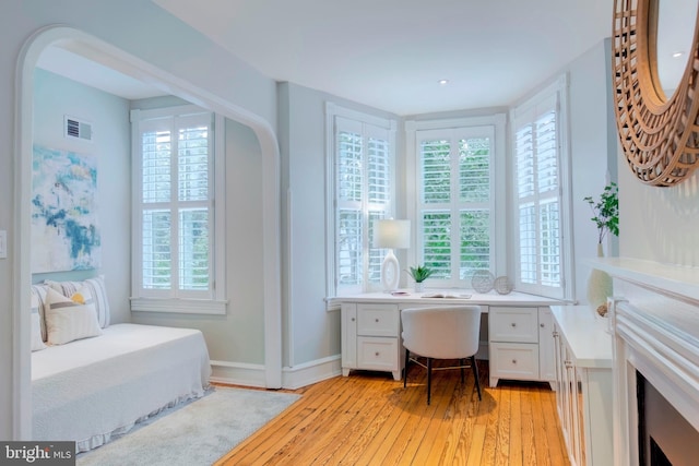 interior space featuring built in desk, a healthy amount of sunlight, and light hardwood / wood-style flooring