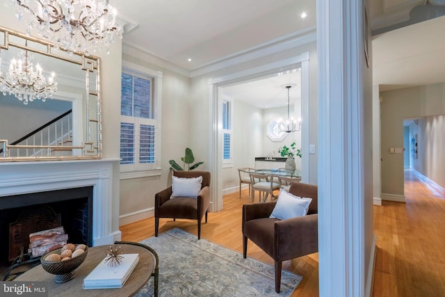 living area with hardwood / wood-style flooring and ornamental molding