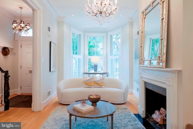 sitting room featuring ornamental molding, a chandelier, and hardwood / wood-style flooring