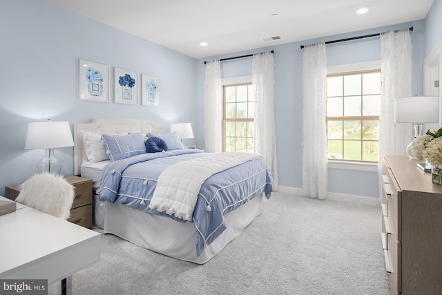 bedroom featuring light carpet and multiple windows