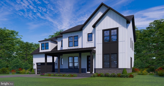 view of front of property featuring a garage, covered porch, and a front yard