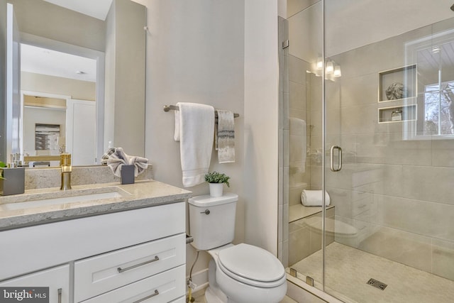 bathroom featuring vanity, toilet, and an enclosed shower