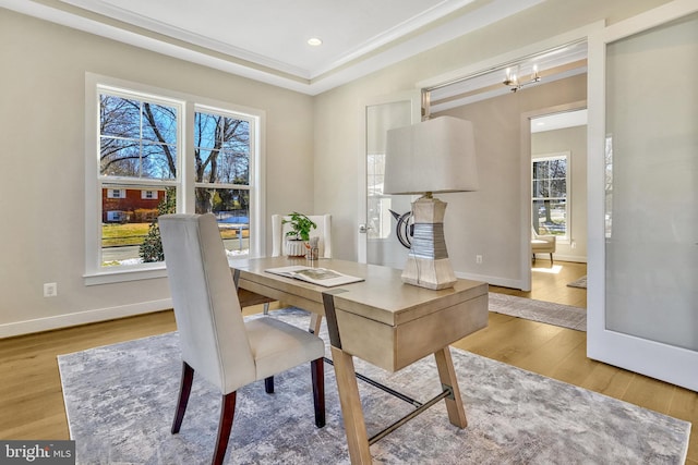 dining space featuring an inviting chandelier, a tray ceiling, and light wood-type flooring