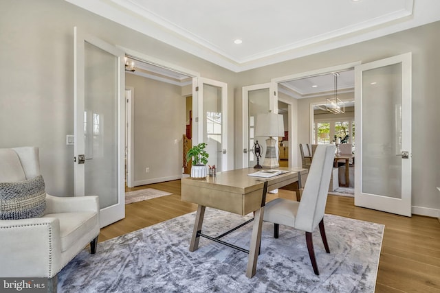 office with french doors, ornamental molding, an inviting chandelier, and hardwood / wood-style flooring