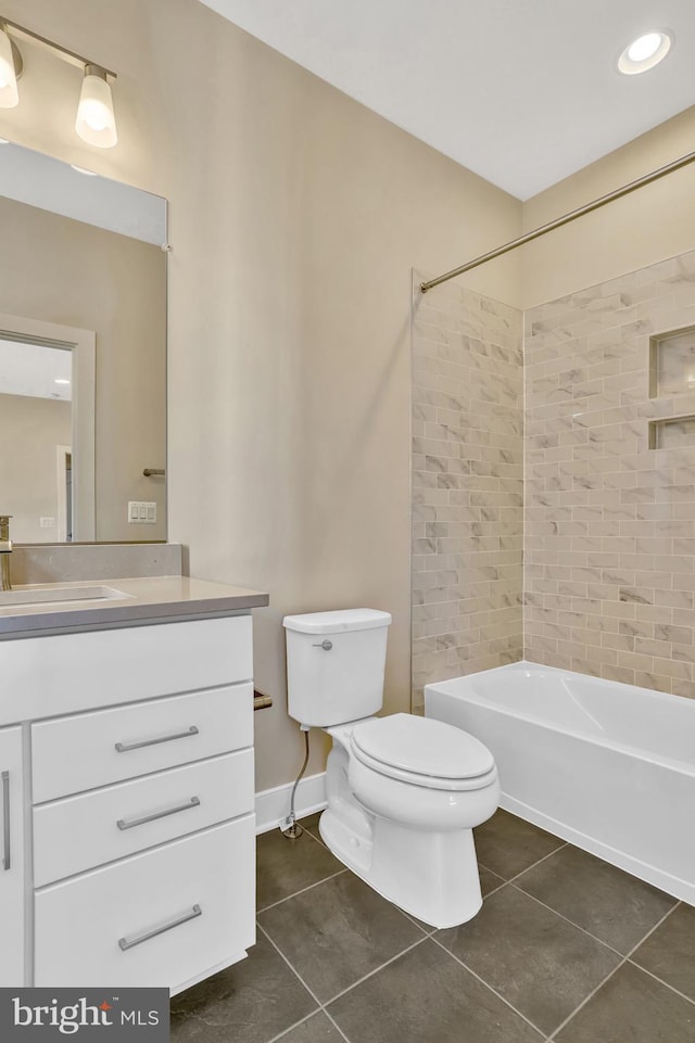 full bathroom featuring vanity, tile patterned floors, toilet, and tiled shower / bath