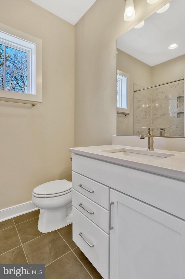 bathroom with vanity, tile patterned floors, toilet, and tiled shower