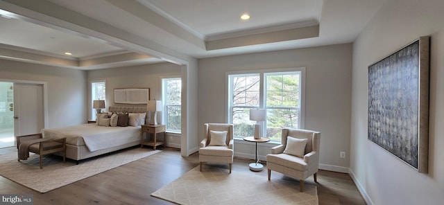 bedroom featuring ornamental molding, a tray ceiling, and light hardwood / wood-style flooring