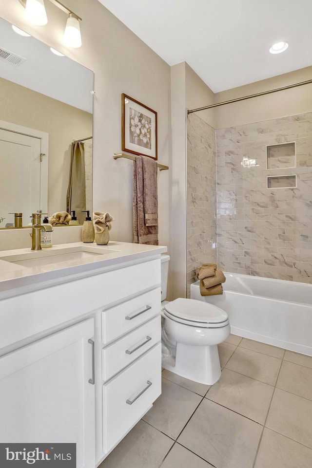 full bathroom with tiled shower / bath, tile patterned floors, toilet, and vanity