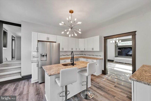 kitchen featuring white cabinets, a center island with sink, dark hardwood / wood-style floors, and stainless steel fridge with ice dispenser