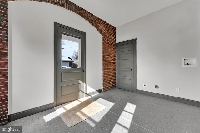 empty room featuring brick wall