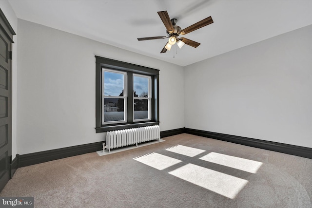 carpeted spare room featuring ceiling fan and radiator heating unit