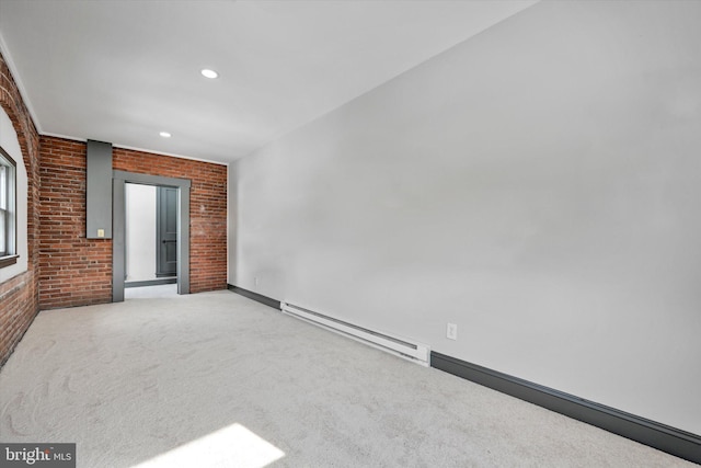 carpeted empty room with brick wall and a baseboard heating unit