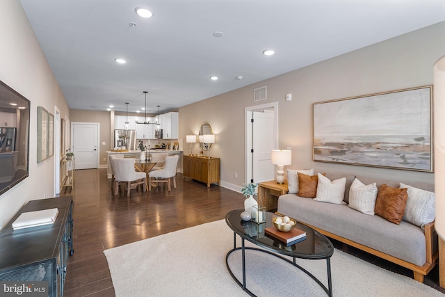living area featuring recessed lighting, visible vents, baseboards, and dark wood-style flooring