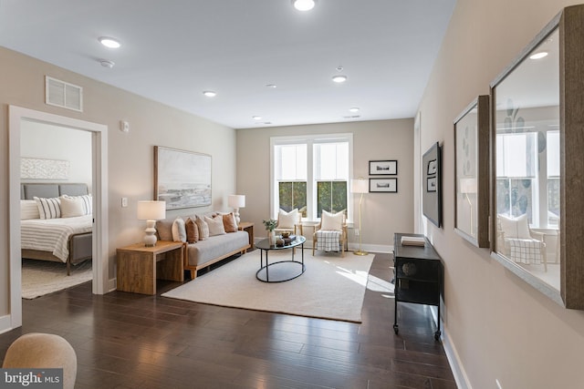 living room featuring baseboards, visible vents, recessed lighting, and dark wood-style flooring