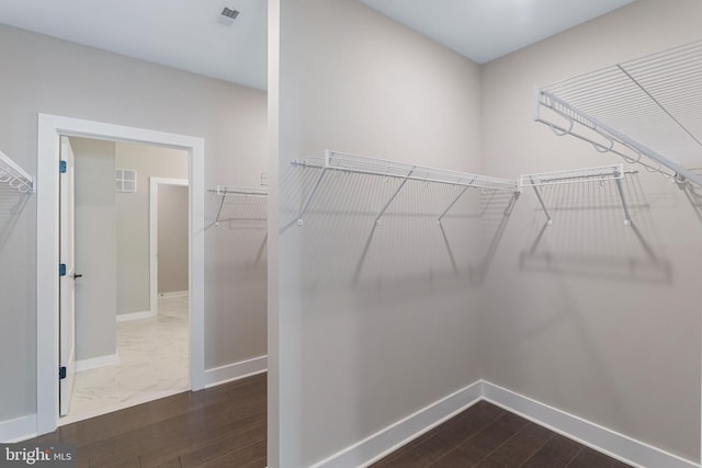 spacious closet featuring visible vents and dark wood-style flooring