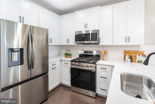 kitchen with sink, tasteful backsplash, white cabinetry, stainless steel appliances, and dark hardwood / wood-style floors