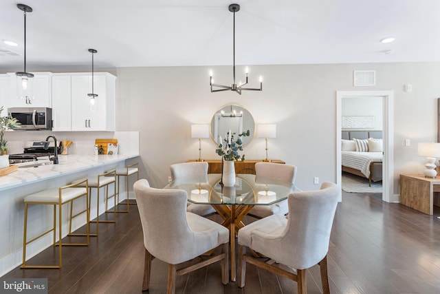 dining area featuring dark hardwood / wood-style floors and a chandelier