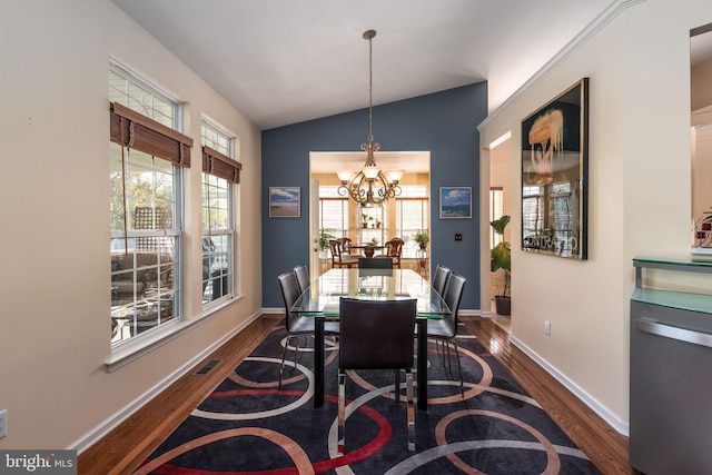 dining room featuring lofted ceiling, a chandelier, dark hardwood / wood-style floors, and plenty of natural light