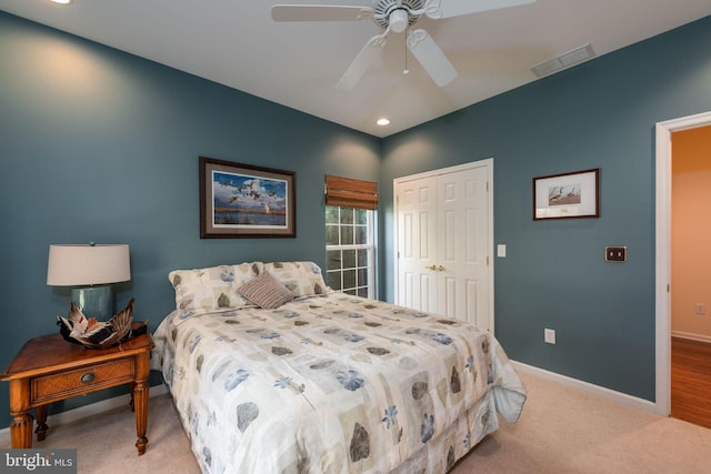 bedroom featuring a closet, light colored carpet, and ceiling fan