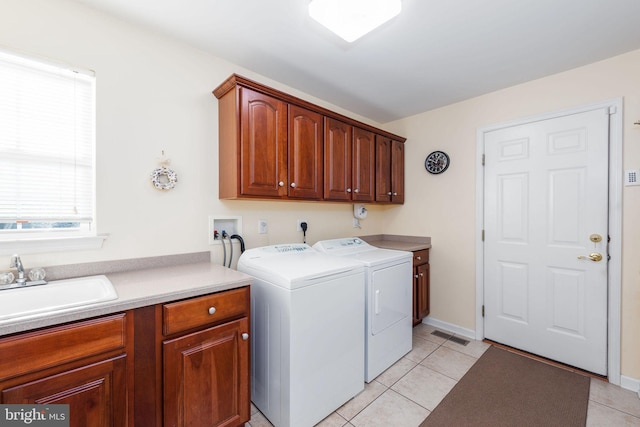 clothes washing area with sink, light tile patterned flooring, cabinets, and washing machine and clothes dryer