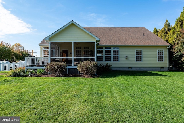 back of property featuring ceiling fan, a lawn, and a sunroom