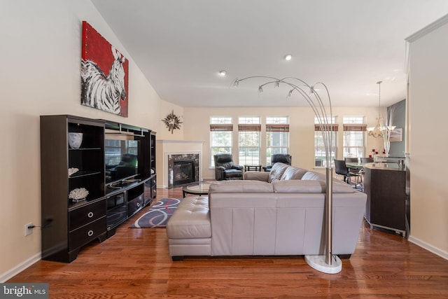 living room with a chandelier, a fireplace, and hardwood / wood-style floors