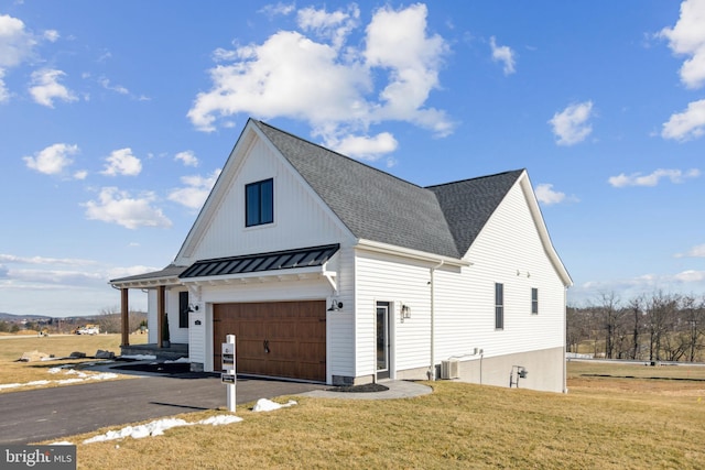 view of side of property featuring cooling unit, a garage, and a yard